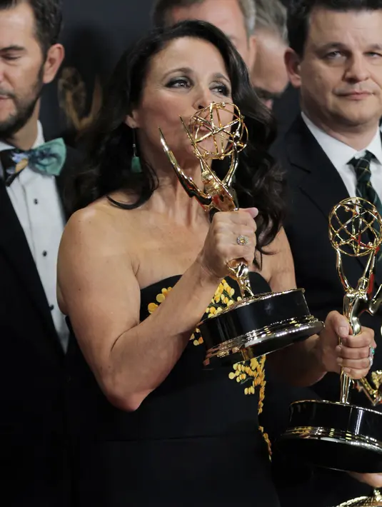 Aktris AS, Julia Louis-Dreyfus mencium trofinya pada ajang Emmy Awards 2017 di Los Angeles, Minggu (17/9). Julia meraih penghargaan Emmy keenamnya sebagai aktris seri komedi lewat Home Box Office (HBO), Veep. (Antonio Pullano/Invision/AP Images)