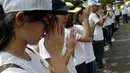Massa yang tergabung dalam Generasi Muda Buddhis Indonesia (Gemabudhi) berdoa sebelum membagikan bunga kepada pengguna jalan di depan Istana Negara, Jakarta, Sabtu (6/1). (Liputan6.com/Immanuel Antonius)