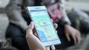 Layar handphone menunjukkan permainan Pokemon Go di area Kampus Universitas Indonesia (UI), Depok, Sabtu (6/8). Game Pokemon Go bisa diunduh langsung oleh pengguna iPhone, iPad, dan smartphone maupun tablet Android. (Liputan6.com/Yoppy Renato)