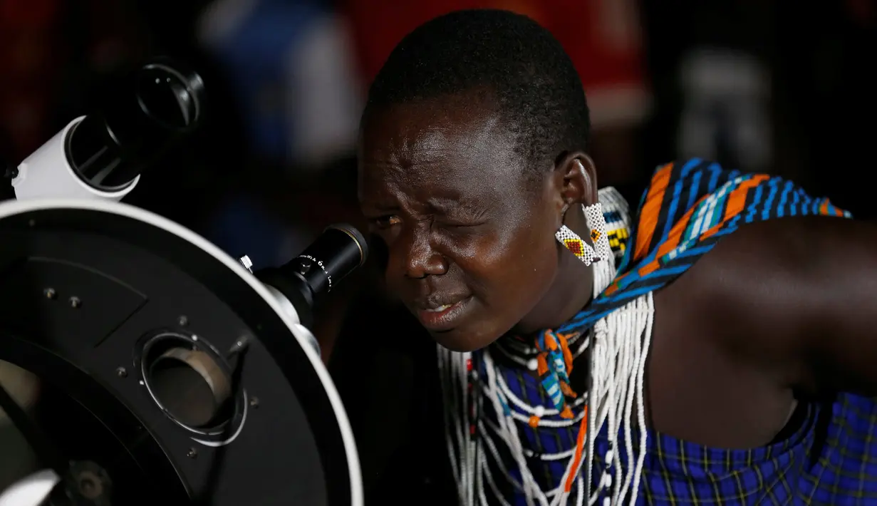Seorang wanita suku Maasai menggunakan teleskop melihat fenomena supermoon di desa Oloika, Shompole, perbatasan Kenya-Tanzanian border, (14/11). Fenomena ini merupakan bulan paling besar dan terang dalam kurun 70 tahun terakhir. (REUTERS/Thomas Mukoya)