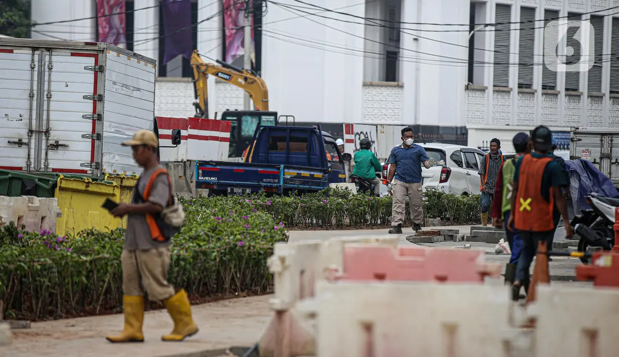 Pekerja menyelesaikan proyek revitalisasi di depan Stasiun Jakarta Kota, kawasan Kota Tua, Jakarta, Sabtu (23/7/2022). Pemprov DKI Jakarta menyatakan program revitalisasi di kawasan Kota Tua salah satunya bertujuan untuk meningkatkan aksesibilitas dengan mengintegrasikan beragam moda transportasi seperti kereta api, MRT, Transjakarta hingga angkutan perkotaan. (Liputan6.com/Faizal Fanani)