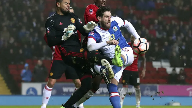 Kiper Manchester United (MU) Sergio Romero (kiri) menghentikan striker Blackburn Rovers Danny Graham pada laga Piala FA di Ewood Park, Minggu (19/2/2017). 