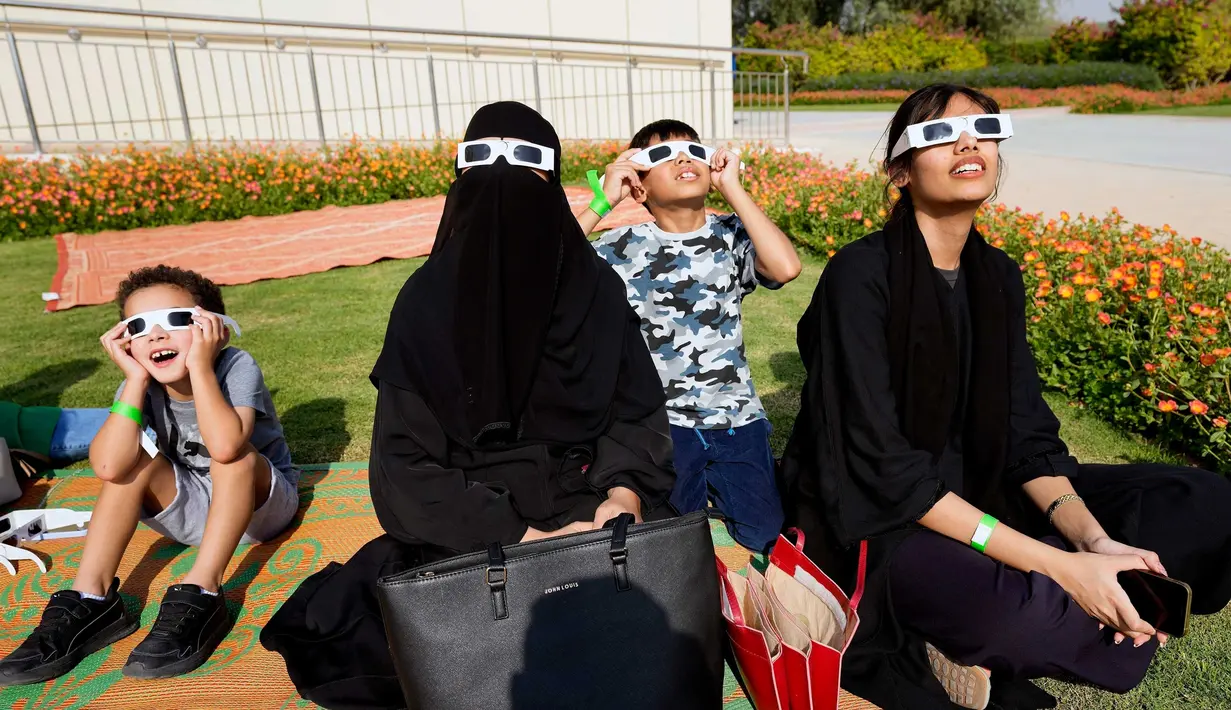 Orang-orang menyaksikan Gerhana Matahari sebagian menggunakan kacamata khusus di Pusat Astronomi Al Thuraya di Dubai, Uni Emirat Arab, Selasa (25/10/2022). Peristiwa Gerhana Matahari terakhir pada tahun 2022 terlihat dari sebagian besar Eropa, serta Afrika Utara, Timur Tengah, dan Asia Barat. (AP Photo/Kamran Jebreili)