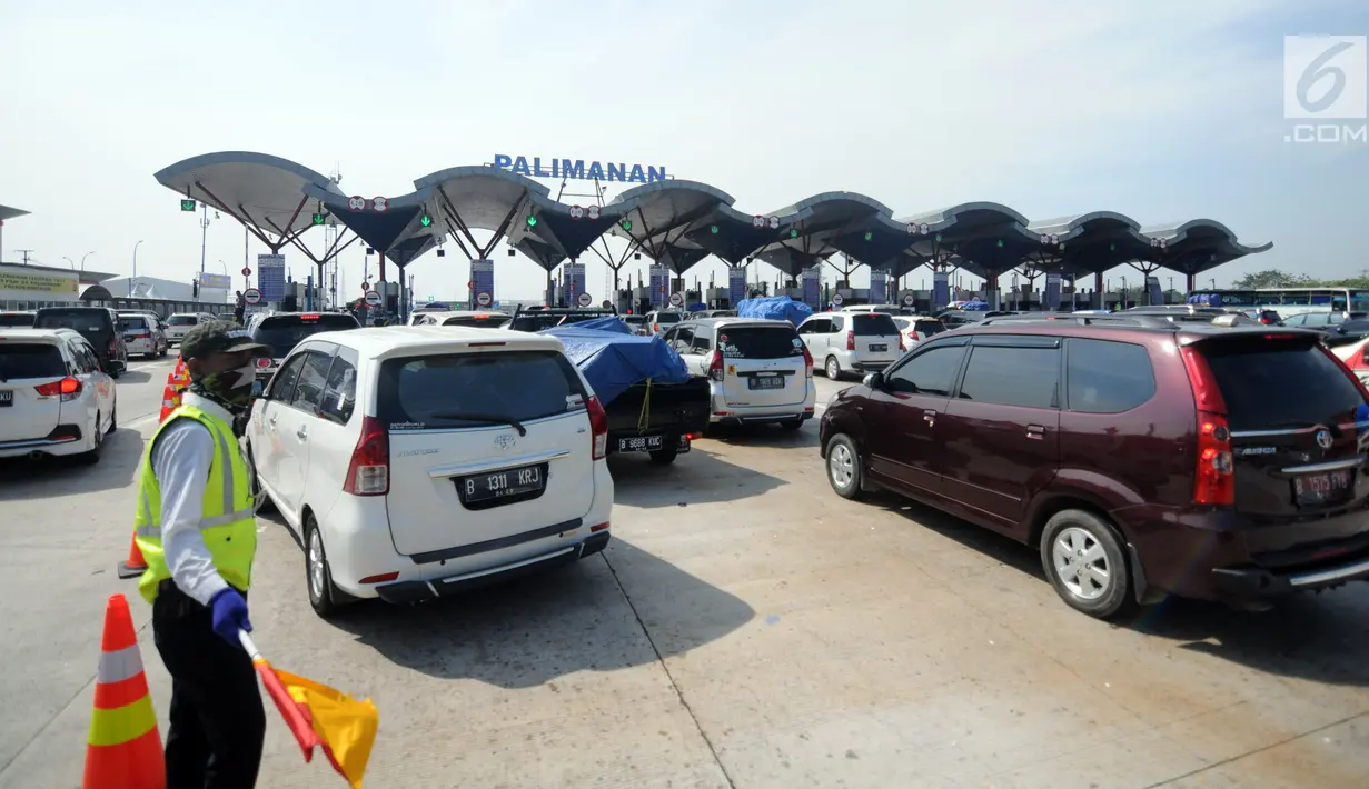 Petugas mengatur arus kendaraan pemudik yang mengantre memasuki gerbang tol Palimanan, Cirebon, Jawa Barat, Rabu (21/6). Memasuki H-4 lebaran, arus mudik di tol Cipali mengalami peningkatan 20 persen dari hari biasa. (Liputan6.com/Gempur M Surya)