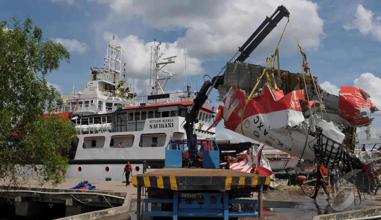 Salah satu bagian ekor pesawat AirAsia QZ8501 diangkat menggunakan Crane dibawa menuju gudang penyimpanan di Pelabuhan Panglima Utar, Kumai, Kalimantan Tengah, Senin (12/01/2015).  (Liputan6.com/Andrian M Tunay)
