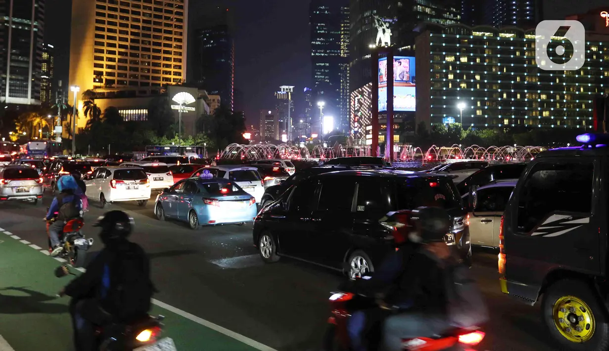 Sejumlah kendaraan melintas di kawasan Bundaran HI, Jakarta, Kamis (31/3/2022). Kawasan Bundaran HI terpantau mulai padat saat jam pulang kantor pada PPKM Level 2. (Liputan6.com/Herman Zakharia)