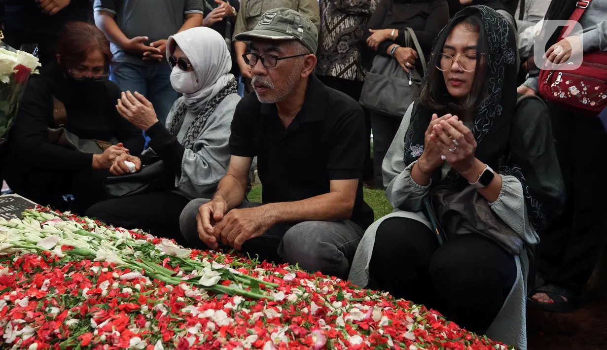 Keluarga dan kerabat berdoa saat prosesi pemakaman aktris senior Aminah Cendrakasih atau Mak Nyak di Taman Pemakaman Umum Karet Bivak, Jakarta, Kamis (22/12/2022). Pemeran Mak Nyak dalam Si Doel Anak Sekolahan meninggal dunia pada 21 Desember 2022 pukul 19.40 WIB karena mengidap penyakit glaukoma yang sudah menahun. (Liputan6.com/Herman Zakharia)
