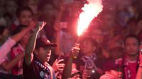 Suporter Persija Jakarta, The Jakmania, menyalakan flare usai mengalahkan Mitra Kukar pada laga Liga 1 di SUGBK, Jakarta, Minggu (9/12). Persija menang 2-1 atas Mitra. (Bola.com/Yoppy Renato)
