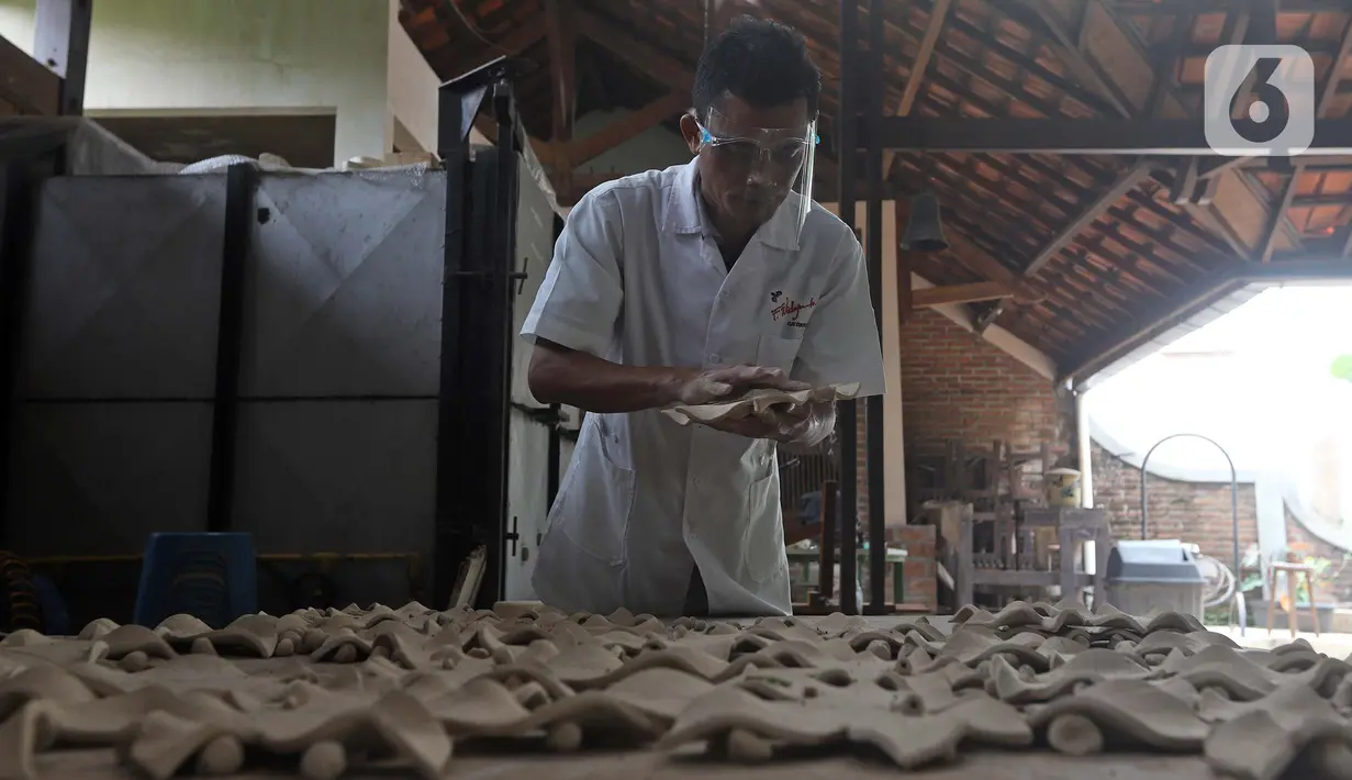 Pekerja menyelesaikan produksi keramik hias di Studio Workshop Rumah Keramik F Widayanto, Tanah Baru, Beji, Depok, Jawa Barat, Rabu (18/11/2020). Bekas tempat wisata edukasi keramik dan berbagai jenis tanah liat itu beralih fungsi menjadi tempat produksi keramik cetak. (Liputan6.com/Herman Zakharia)