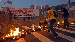 Dalam aksinya, pekerja kereta bawah tanah dan anggota MTST (Gerakan Pekerja Tunawisma) Brasil memblokade jalan dengan membakar beberapa atribut, Sao Polo, (9/6/2014). (AFP PHOTO/NELSON Almeida)