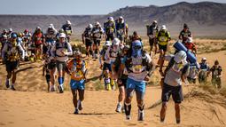 Para peserta bersaing dalam lomba lari Marathon des Sables ke-34 tahap kedua di Gurun Sahara, Maroko, Minggu (7/4). Lomba yang diselenggarakan sejak tahun 1986 ini digelar di Gurun Sahara pada bulan April. (JEAN-PHILIPPE KSIAZEK/AFP)