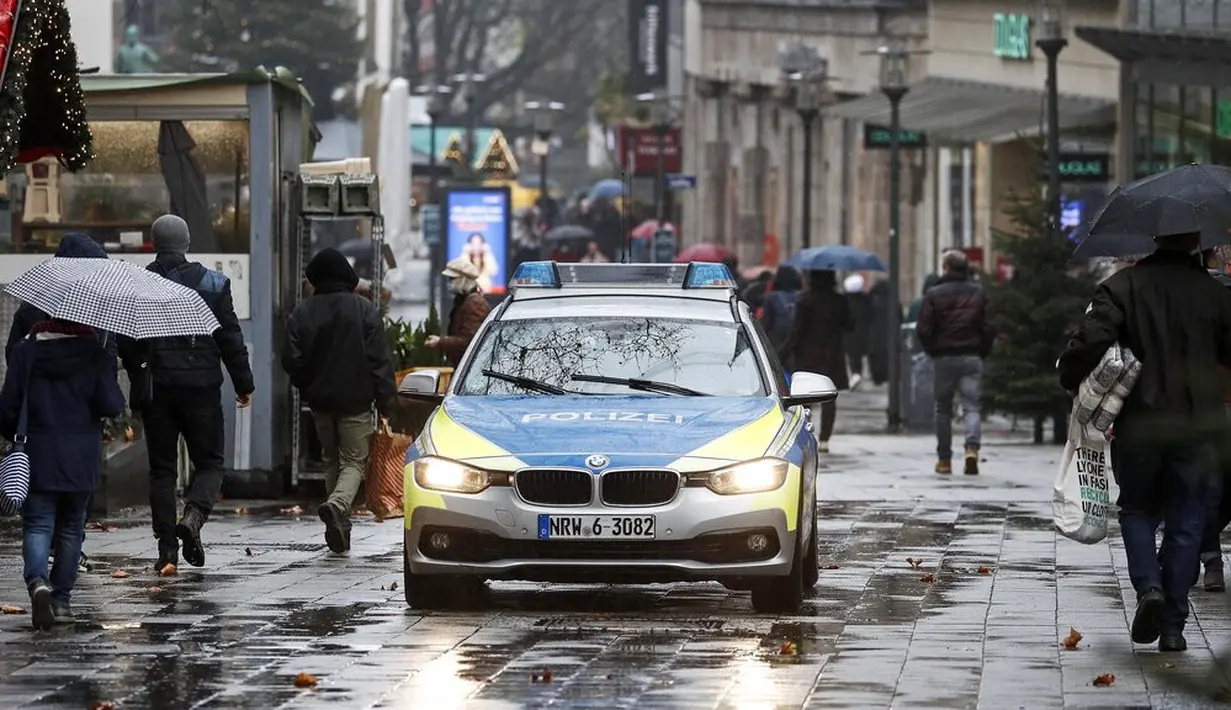 Sebuah mobil polisi melaju di jalan pusat Kota Essen, Jerman, Senin (14/12/2020). Jerman melakukan lockdown nasional pada 16 Desember 2020 untuk memerangi pandemi COVID-19. (AP Photo/Martin Meissner)