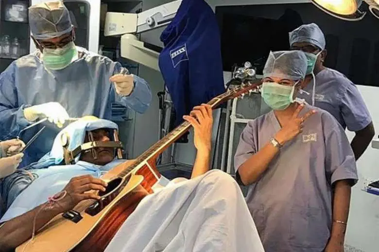 Abhishek Prasad (37) menjalani operasi otak sambil bermain gitar. Cara ini dinilai membantu dalam proses penyembuhan (AFP)