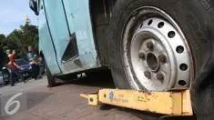 Sebuah mobil angkutan kota yang digembok terparkir di kawasan Monas, Jakarta, Selasa (3/1). Sejak Januari hingga Desember 2016, Dinas Perhubungan dan Transportasi DKI menerima retribusi derek lebih dari Rp 10 miliar. (Liputan6.com/Immanuel Antonius)