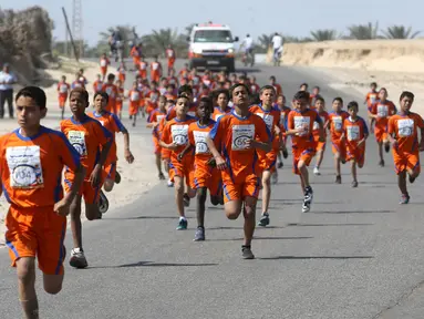 Sejumlah anak Palestina berlari selama mengikuti maraton yang diselenggarakan oleh Culture and Free Thought association di Khan Younis di Jalur Gaza selatan (28/4/2016). (REUTERS / Ibraheem Abu Mustafa)