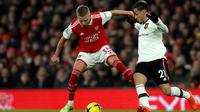 Oleksandr Zinchenko berduel melawan Antony dalam laga Arsenal versus Manchester United di Emirates Stadium, London, Minggu (22/1/2023). (AP/Ian Walton)
