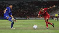 Bek Timnas Indonesia U-20, Dony Tri Pamungkas (kanan) bersiap melepaskan tembakan yang berusaha diblok bek Thailand U-20, Jirapol Sae Lio pada laga uji coba di Stadion Utama Gelora Bung Karno (SUGBK), Senayan, Jakarta, Jumat (26/1/2024) malam WIB. (Bola.com/M Iqbal Ichsan)