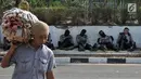 Polisi beristirahat di trotoar akses menuju Gedung DPR RI di Jalan Gatot Subroto, Jakarta, Kamis (26/9/2019). Polisi menutup jalan mulai dari simpang Gerbang Pemuda guna mengantisipasi adanya aksi unjuk rasa susulan. (merdeka.com/Iqbal S Nugoroho)