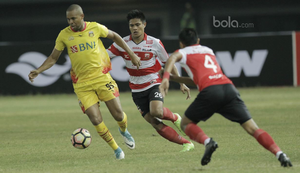 Striker Bhayangkara FC, Thiago Furtuoso, berusaha melwati bek Madura United, Asep Berlian pada laga lanjutan liga 1 di Stadion Patriot, Bekasi, kamis (13/7/2017). Bhayangkara FC menang 2-1 atas Madura United. (Bola.com/M Iqbal Ichsan)