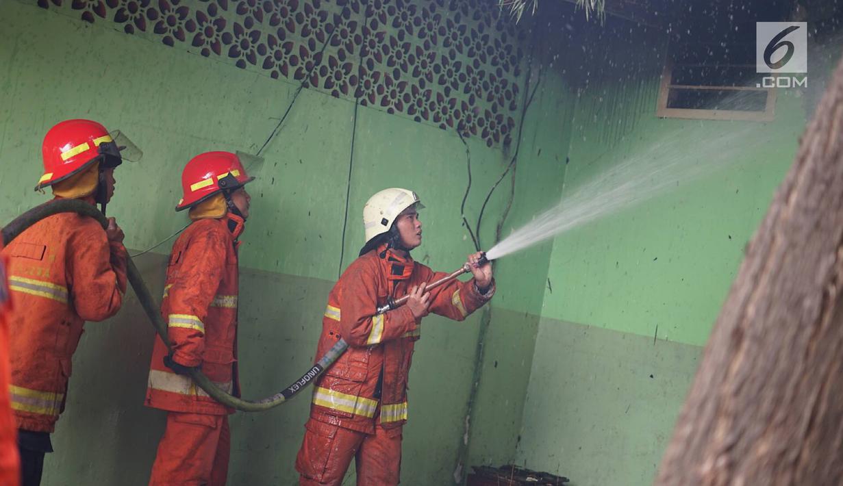 Petugas berusaha memamkan api yang membakar area kantin kampus Institut Ilmu Sosial dan Ilmu Politik (IISIP), Jakarta, Sabtu (24/8/2019). Api diduga berasal dari hubungan pendek arus listrik. (Liputan6.com/Immanuel Antonius)