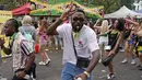 Orang-orang yang bersuka ria saat Karnaval Notting Hill tahunan di London barat, Senin (29/8/2022). Karnaval yang kembali ke jalanan untuk pertama kalinya dalam dua tahun, setelah digagalkan oleh pandemi, adalah salah satu perayaan festival terbesar dari jenisnya di Eropa. (AP Photo/Alberto Pezzali)