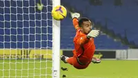 Kiper Brighton and Hove Albion, Robert Sanchez menepis tendangan gelandang Tottenham Hotspur, Carlos Vinicius dalam laga lanjutan Liga Inggris 2020/21 pekan ke-21 di American Express Community Stadium, Minggu (31/1/2021). Brighton menang 1-0 atas Tottenham. (AFP/Andrew Boyers/Pool)