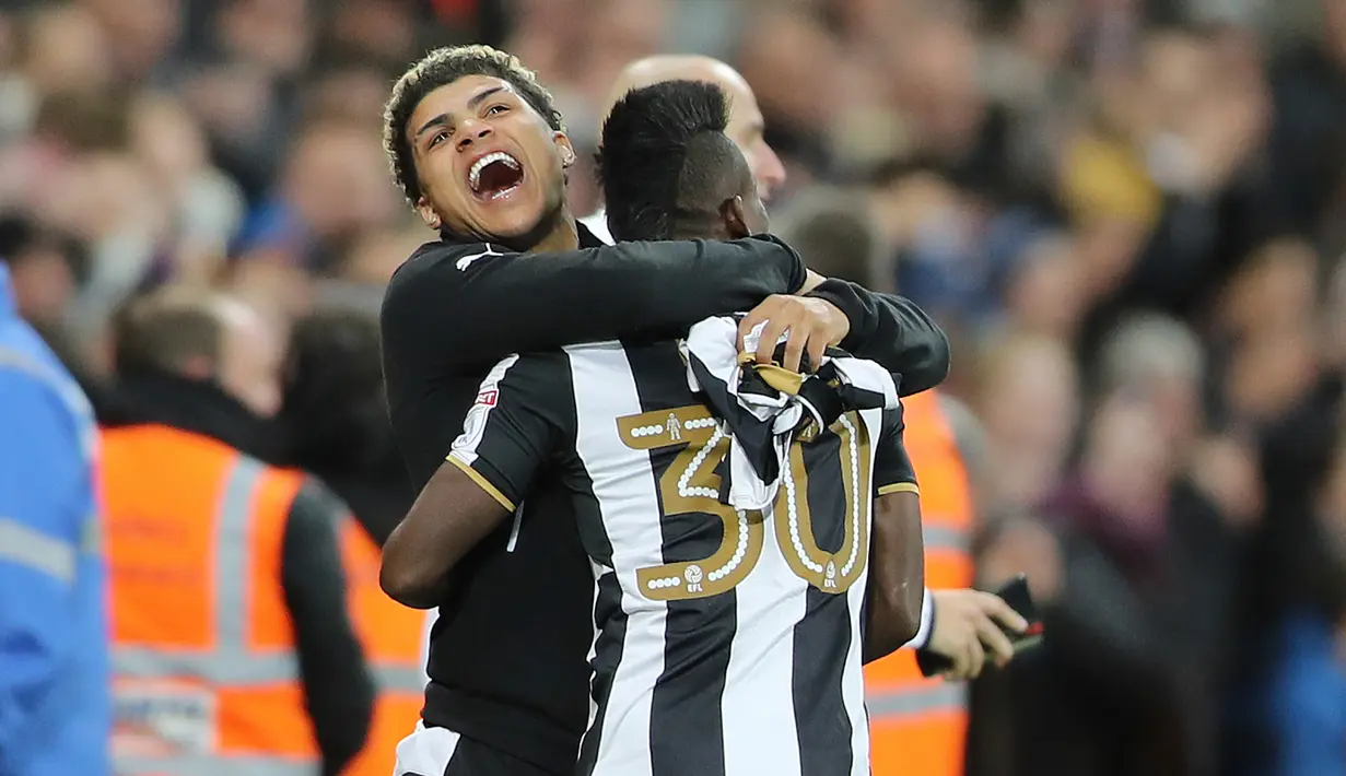 Gelandang Newcastle, Christian Atsu memeluk rekan setimnya merayakan kemenangan atas Preston North End dalam Sky Bet Championship di Newcastle, (25/4). Newcastle United promosi ke liga Primer inggris. (Owen Humphreys/PA Wire)