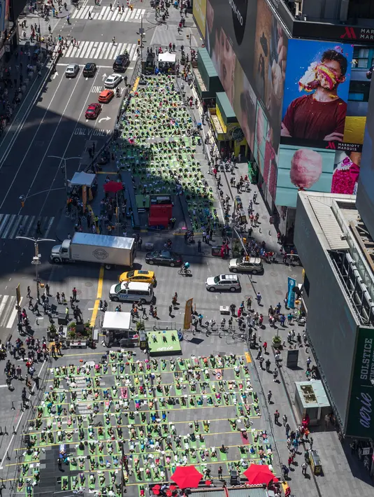Sejumlah orang melakukan gerakan yoga saat matahari mencapai titik balik di musim panas (summer solstice) di kawasan Times Square, New York, Kamis (21/6). Ribuan orang berkumpul untuk merayakan titik balik matahari di musim panas. (AP Photo/Mary Altaffer)