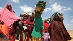 Sejumlah wanita Somalia membawa alas dan perlengkapan lainnya saat mengungsi akibat kekeringan yang melanda kawasannya di daerah Tabelaha di pinggiran Mogadishu, Somalia (30/3). (AP Photo/Farah Abdi Warsameh)