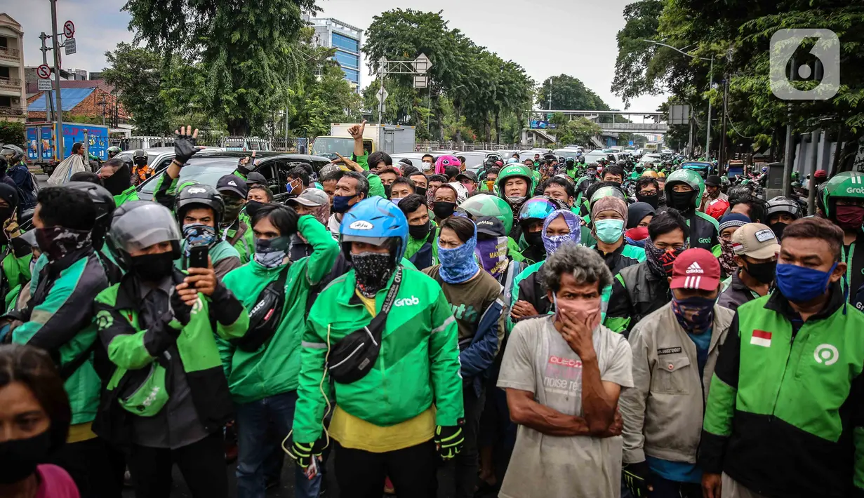 Warga dan pengemudi ojek online mengantre nasi kotak serta masker dari TNI di Markas Komando Gabungan Wilayah I, Jakarta, Selasa (21/4/2020). Dalam rangka Hari Kartini, TNI membagikan makanan dan masker kepada masyarakat. (Liputan6.com/Faizal Fanani)