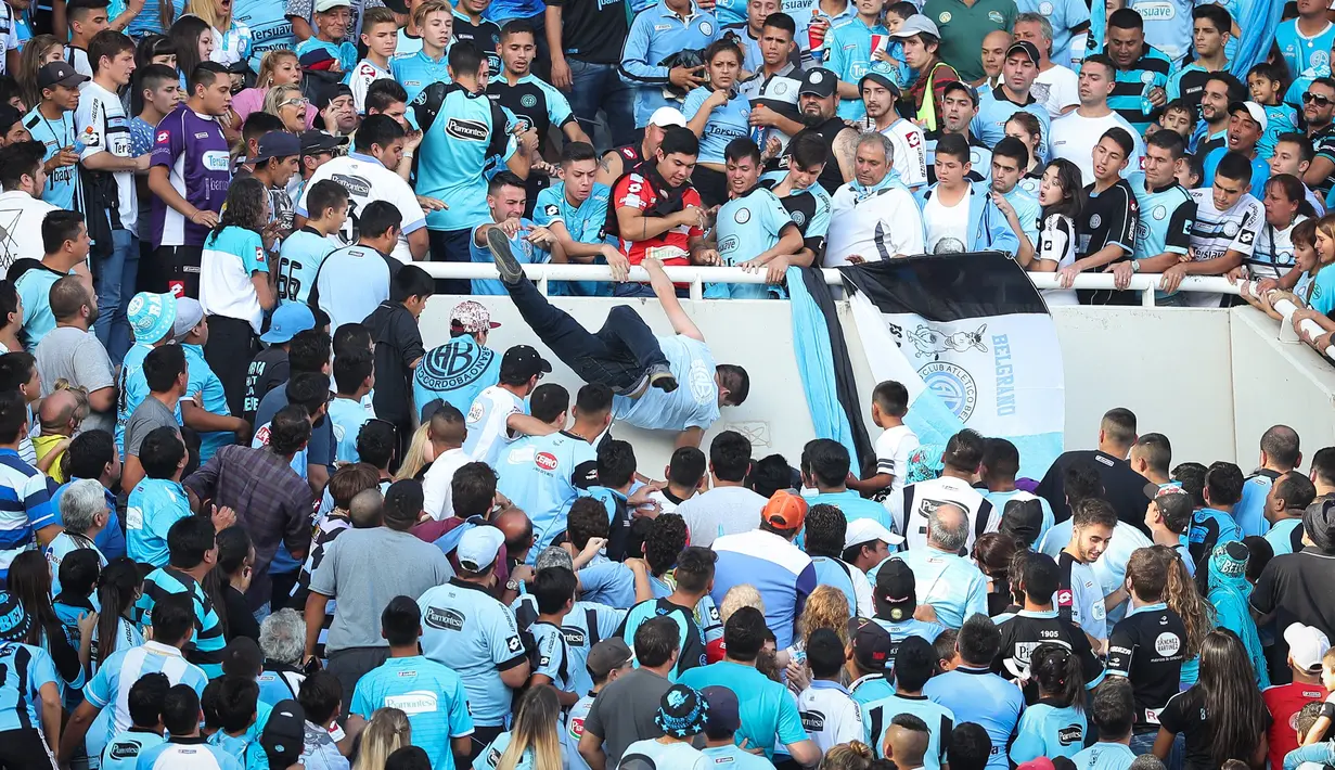 Seorang fans dari tim Belgrano, Emanuel Balbo, didorong oleh pendukung lainnya hingga jatuh dari tribun Stadion Belgrano, Kota Cordoba di Argentina, 15 April 2017. Insiden terjadi ketika Belgrano berhadapan dengan tim tamu, Talleres (NICOLAS AGUILERA/AFP)