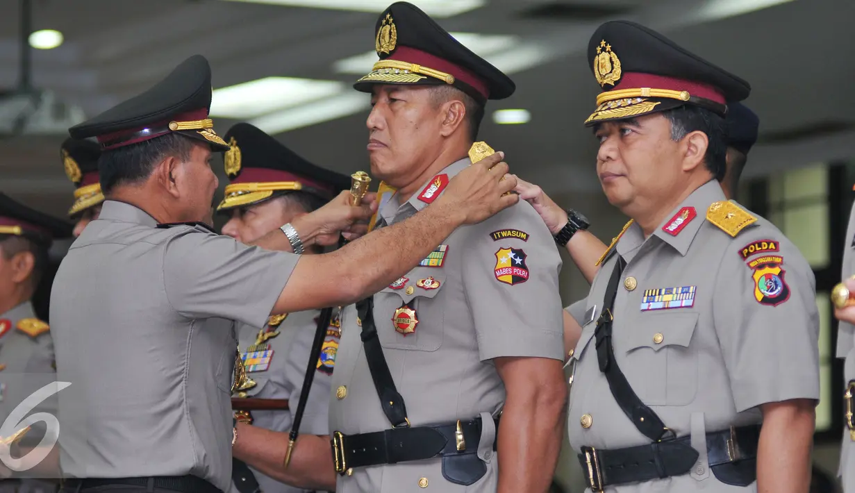 Kapolri Jenderal Badrodin Haiti (kiri) melepas tanda pangkat Brigjen Pol Endang Sunjaya (kedua kanan) saat Serah Terima Jabatan Pejabat Tinggi Polri dan Kapolda di Rupatama Mabes Polri, Senin (11/1). (Liputan6.com/Gempur M Surya)