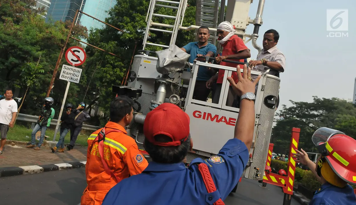 Agustinus Woro usai turun dari baliho di seberang Kantor Pelayanan Pajak Pratama Setiabudi Satu, Jakarta, Jumat (26/5). Sebelum turun, Agustinus minta dipanggilkan pengacaranya dan dibelikan nasi padang. (Liputan6.com/Helmi Afandi)