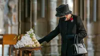 Ratu Elizabeth II menyentuh buket bunga yang diletakkan di makam Pahlawan Tak Dikenal untuk menandai seratus tahun pemakaman Prajurit Tak Dikenal menjelang Remembrance Sunday di Westminster Abbey di London pada 4 November 2020. (AARON CHOWN / POOL / AFP)