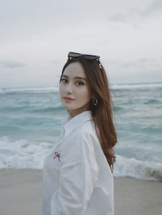 Salshabilla Adriani juga liburan ke Bali setelah lebaran. Saat di pantai, ia mengenakan kemeja oversize putih. Ia juga mengenakan kacamata hitam dan anting-anting silvernya. [@salshabillaadr]