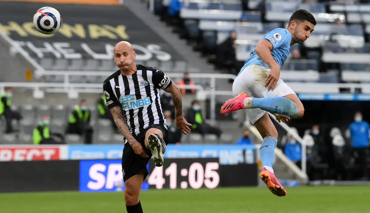 Gelandang Manchester City, Ferran Torres (kanan) melepaskan tendangan yang berbuah gol kedua timya ke gawang Newcastle United dalam laga lanjutan Liga Inggris 2020/2021 pekan ke-36 di St James' Park, Newcastle, Jumat (14/5/2021). Manchester City menang 4-3 atas Newcastle. (AFP/Stu Forster/Pool)