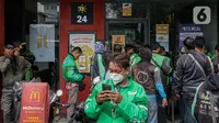 Sejumlah pengemudi ojek online berkerumun saat antre mengambil pesanan di gerai cepat saji McDonald's Raden Saleh, Jakarta, Rabu (9/6/2021). BTS Meal merupakan menu kolaborasi boyband asal Korea, BTS, dengan McDonald's yang hadir di 50 negara termasuk Indonesia. (Liputan6.com/Faizal Fanani)