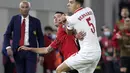 Gelandang Albania Odise Roshi dan bek Polandia Jan Bednarek berebut bola pada lanjutan Grup I Kualifikasi Piala Dunia 2022 Zona Eropa, di Air Albania Stadium, Rabu (13/10/2021) dini hari WIB.  Kemenangan Polandia 1-0 atas Albania diwarnai aksi pelemparan botol oleh suporter. (AP Photo/Franc Zhurda)