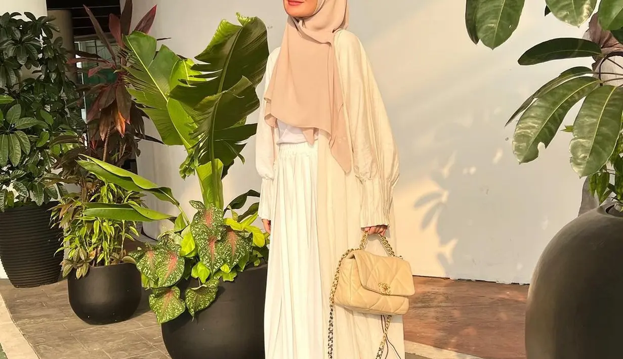 Atau bisa juga tiru gaya Shireen Sungkar yang memadukan kardigan panjang dengan blouse, dan rok warna putih yang senada. Untuk warna hijab, kamu bisa pilih yang sesuai dengan warna kardigan. (Instagram/shireensungkar).