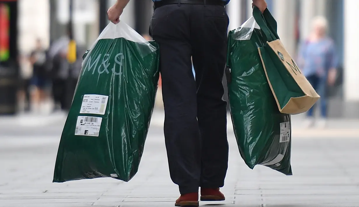Seorang pelanggan meninggalkan toko Marks and Spencer di pusat kota London, Selasa (18/8/2020). Peretail Inggris, Marks & Spencer pada Selasa (18/8) mengumumkan rencananya untuk memangkas 7.000 pekerja dalam tiga bulan ke depan di tengah pandemi COVID-19. (Photo by JUSTIN TALLIS / AFP)