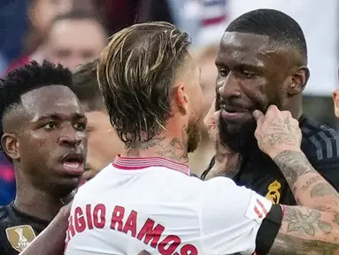 Pemain Sevilla, Sergio Ramos, mencubit pipi pemain Real Madrid, Antonio Rudiger, pada laga Liga Spanyol di Stadion Ramon Sanchez Pizjuan, Sabtu (21/10/2023). (AP Photo/Jose Breton)