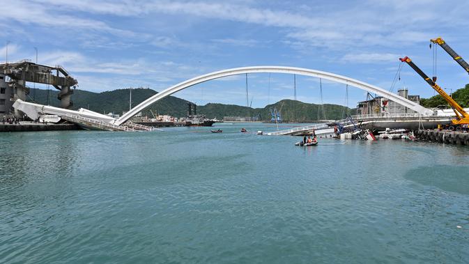 Sebuah jembatan  yang ambruk di pelabuhan ikan Nanfangao di kota Suao (1/10/2019). Jembatan beton yang ambruk tersebut menimpa beberapa perahu nelayan yang bersandar di bawahnya. (AFP Photo/Sam Yeh)