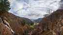 Panorama dari 27 foto yang diambil pada 3 Maret 2023 menunjukkan jembatan gantung yang sedang dibangun, menghadap ke air terjun di Todtnau, barat daya Jerman. Pembangunan jembatan sepanjang 450 meter yang digantung dengan ketinggian hingga 120 meter ini diharapkan selesai pada Mei 2023 dan menjadi daya tarik wisata utama di Black Forest. (PATRICK HERTZOG / AFP)