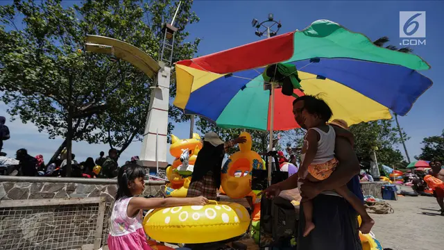 Libur Natal, Warga Menikmati Liburan Murah Meriah di Pantai Ancol