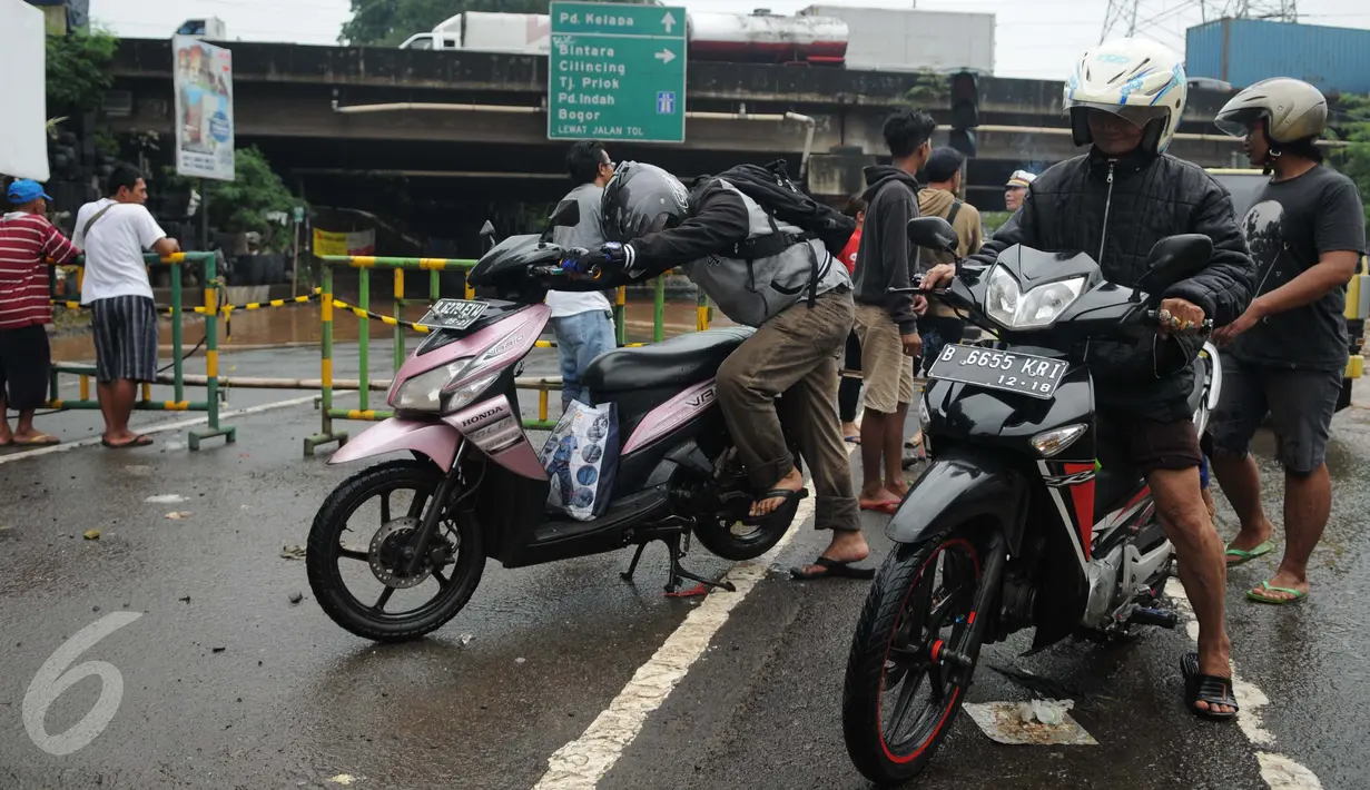 Sejumlah pengendara motor mengecek kendaraan mereka setelah menerobos banjir di Jalan Raya Kalimalang, Caman, Bekasi, Senin (20/2). Banjir setinggi 80 cm itu menyebabkan jalur dari arah Jakarta menuju Kota Bekasi tersendat. (Liputan6.com/Gempur M Surya)