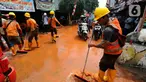 Petugas membersihkan tanah merah berlumpur   di Jalan PLN Raya Gandul  di Kecamatan Cinere, Depok, Jawa Barat, Rabu (31/8/2022). Tanah merah naik dari dalam tanah akibat  proyek pekerjaan Kabel SKTT 150kV Gandul-Kemang,  menyebabkan jalan dipenuhi tanah merah berlumpur. (merdeka.com/Arie Basuki)