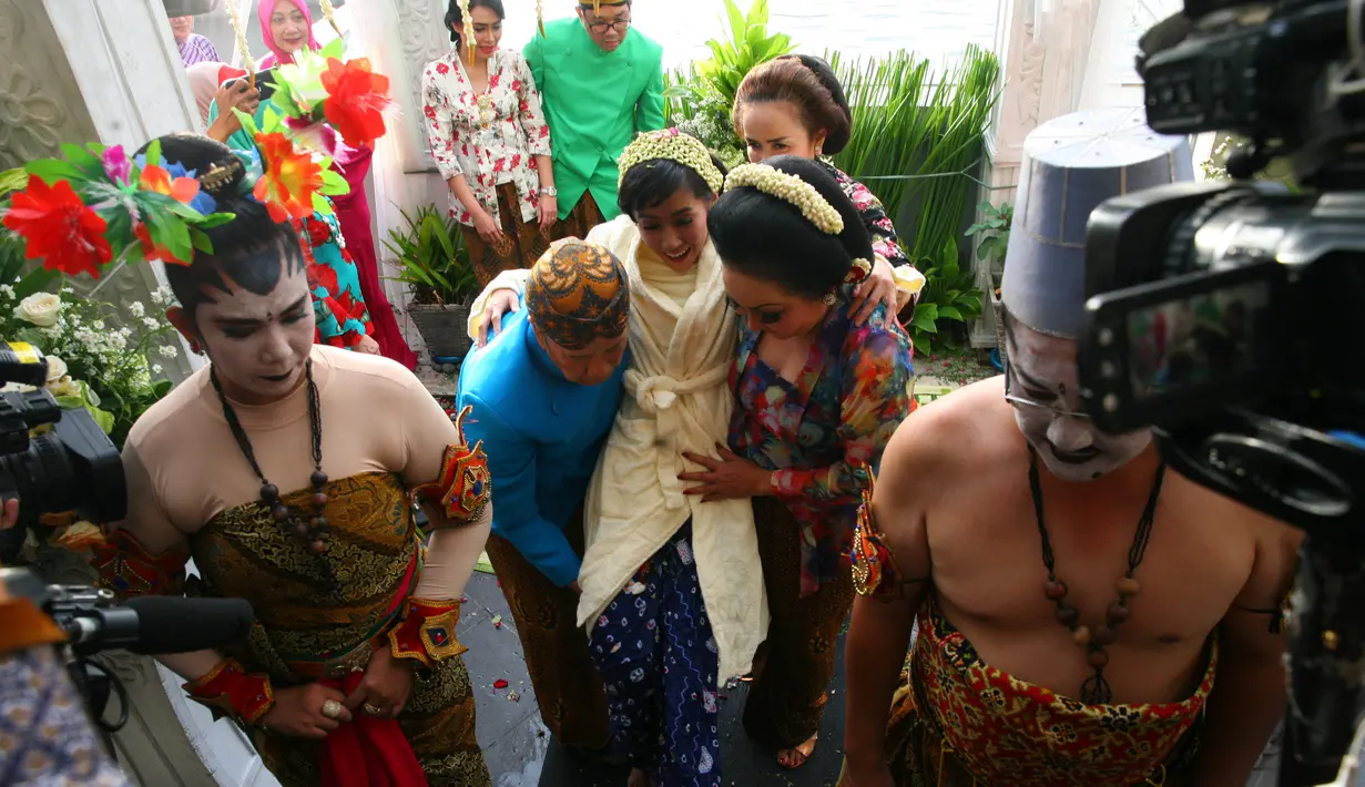 Selesai acara siraman, Rasti tubuh Rasti di balut dengan handuk. Papa dan mamanya terlihat akan mengangkat Rasti. Lantaran ayahnya yang sudah sepuh, ayah gendong anak hanya sebatas dokumentasi. (Nurwahyunan/Bintang.com)