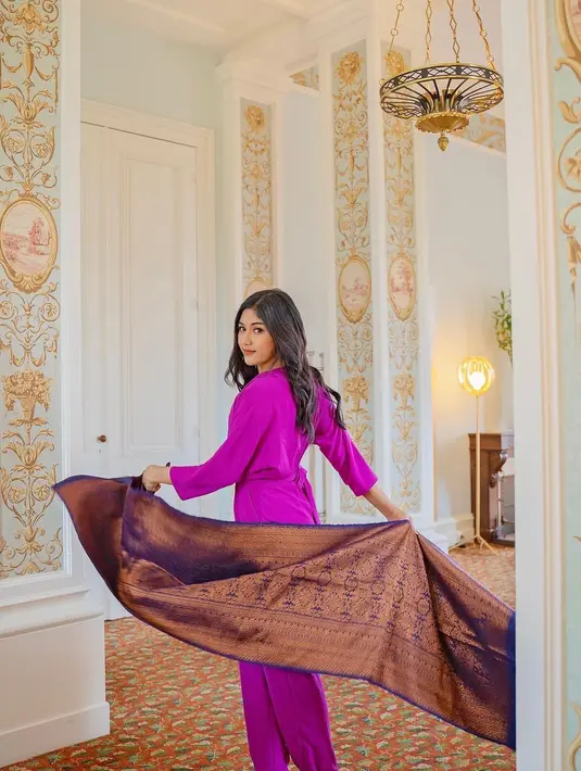 Jumpsuit berwarna ungu itu bikin kain Nusantara terlihat modern dikenakan Erina Gudono. [@erinagudono]