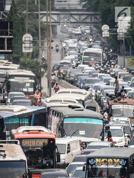 Kendaraan roda dua dan empat tampak terjebak macet panjang di kawasan Jalan Gatot Subroto, Jakarta, Minggu (9/12). Kemacetan tersebut diakibatkan oleh ribuan suporter yang ingin menunju ke Stadion Gelora Bung Karno. (Liputan6.com/Faizal Fanani)