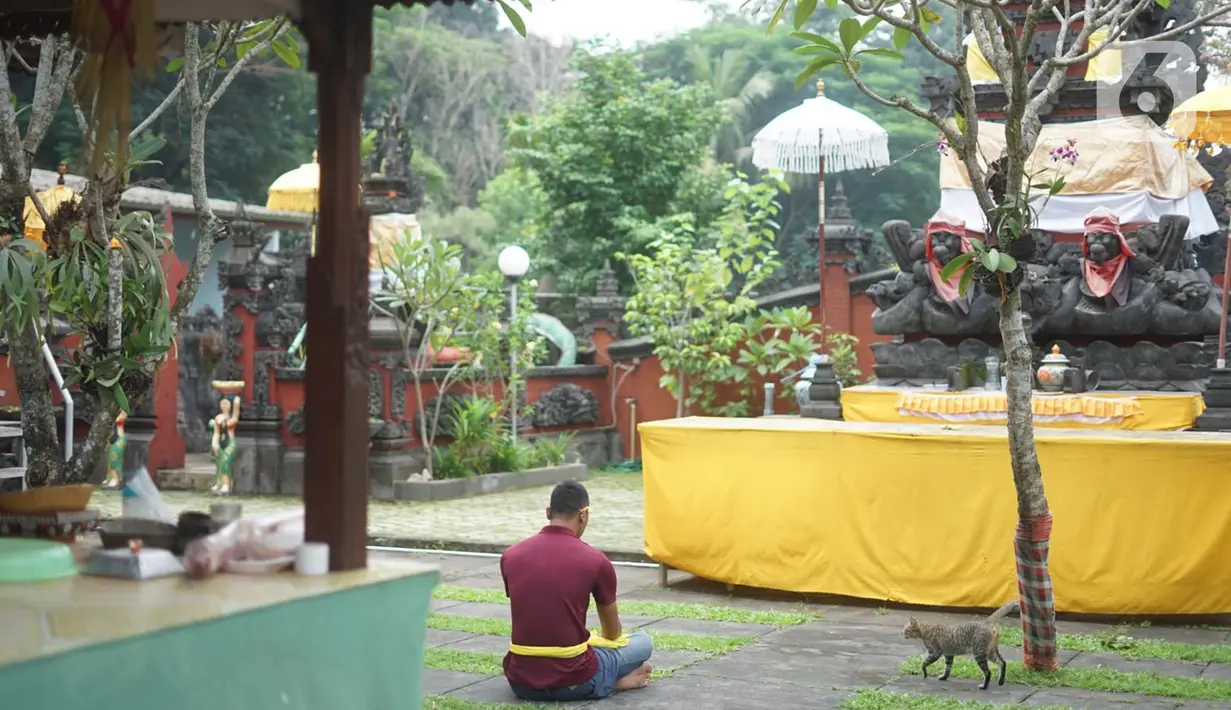Umat Hindu berdoa di Pura Widya Dharma yang sepi di kawasan Cibubur, Jakarta Timur, Selasa (24/3/2020). Pembatasan aktivitas menjelang Hari Raya Nyepi tahun baru Saka 1942 dilakukan sesuai dengan imbauan pemerintah untuk antisipasi penyebaran virus corona Covid-19. (Liputan6.com/Immanuel Antonius)